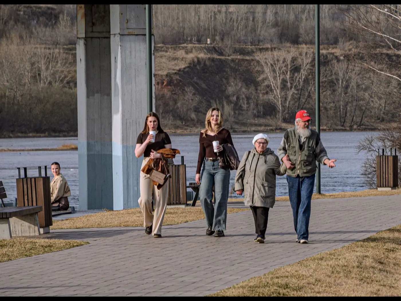 A group of different ages walking together along a riverside path
